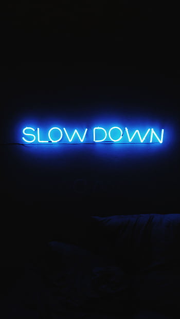 A glowing blue neon sign reads 'Slow Down' against a dark backdrop, creating a modern aesthetic. HD phone wallpaper