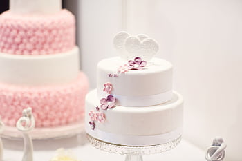 A beautifully decorated white wedding cake with elegant floral designs, perfect for weddings. HD wallpaper