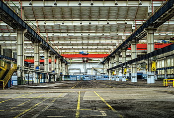 Expansive industrial warehouse interior showcasing steel framework and spacious layout for diverse manufacturing needs. HD wallpaper