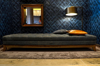 A stylish and modern bedroom featuring a cozy daybed and ambient floor lamp. HD wallpaper