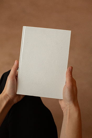 A minimalist blank white book held by hands against a neutral background. HD phone wallpaper
