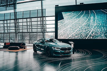Elegant luxury coupe showcased in a modern Munich auto showroom with glass architecture. HD wallpaper