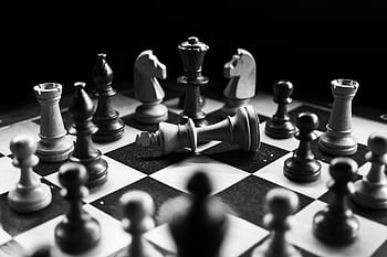 A captivating black and white of a chess game with fallen king piece, symbolizing defeat. HD wallpaper