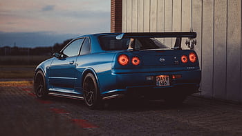 A blue Nissan Skyline GTR parked outdoors at twilight in Roskilde, Denmark. HD wallpaper