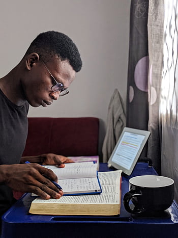 Young man deeply immersed in reading and studying with books and tablet. HD phone wallpaper