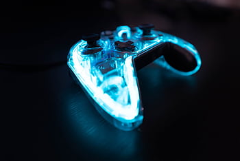 Illuminated gaming controller with blue lights on a dark background, perfect for gaming themes. HD wallpaper