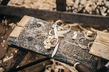 Rustic workbench covered in wood shavings, showcasing detailed craftsmanship. HD wallpaper