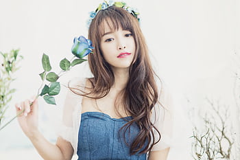 Beautiful portrait of a woman with a blue rose and flower crown, showcasing grace and elegance. HD wallpaper