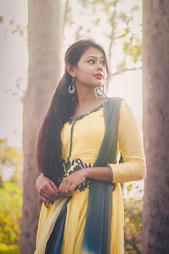 Portrait of a young woman in traditional Indian dress surrounded by trees, exuding elegance and grace. HD phone wallpaper