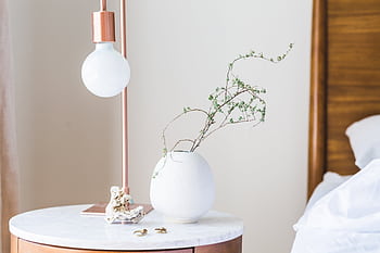 Stylish bedroom with a minimalist lamp and vase on a marble side table. HD wallpaper