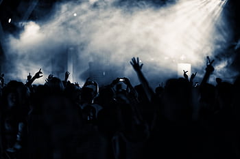 A lively nightclub concert scene with a cheering crowd illuminated by blue lights. HD wallpaper