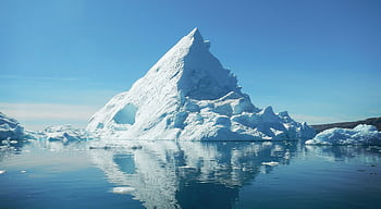 Stunning view of a towering iceberg reflecting in the calm waters of Tiniteqilaaq, Greenland. HD wallpaper