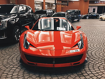 Red Ferrari sports car showcased at Dubai Mall, UAE, symbolizing luxury and elegance. HD wallpaper