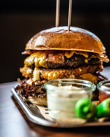 Delicious gourmet cheeseburger paired with fries and dips, perfect for food lovers. HD phone wallpaper