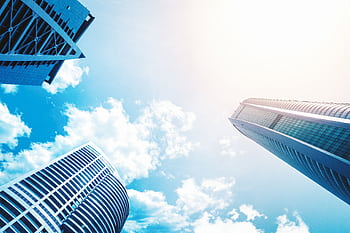 Upward view of modern skyscrapers against a vivid blue sky showcasing contemporary architecture. HD wallpaper