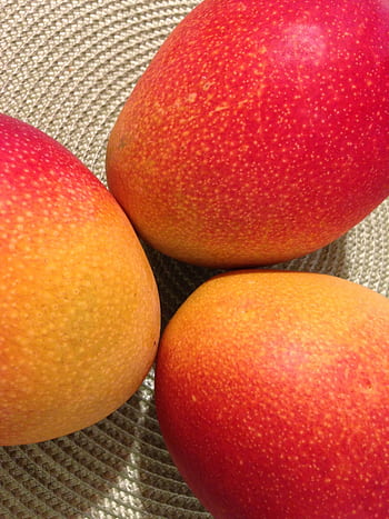 Close-up shot of vibrant, ripe mangoes showcasing their colorful texture and fresh appeal. HD phone wallpaper