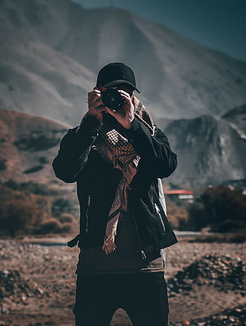 A grapher in dark attire taking in a mountainous terrain during the day. HD phone wallpaper
