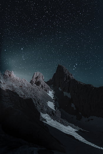Breathtaking view of a rocky mountain peak under a starry night sky, perfect for . HD phone wallpaper
