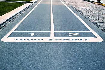 Close-up of outdoor 100m sprint track lanes, perfect for athletics and sprinting events. HD wallpaper