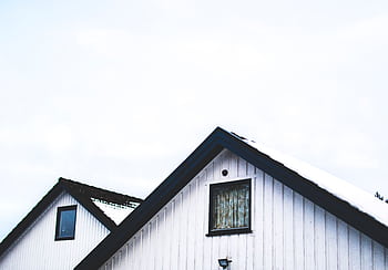 White bungalow roof with snow against a clear sky. HD wallpaper