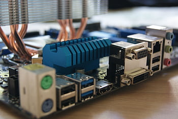 Detailed view of computer motherboard with various ports and connectors. HD wallpaper
