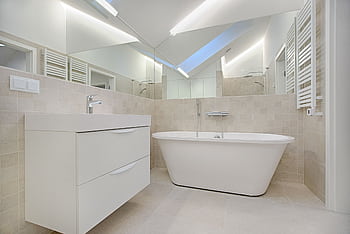 Elegant minimalist bathroom featuring a white bathtub and sleek fixtures. HD wallpaper