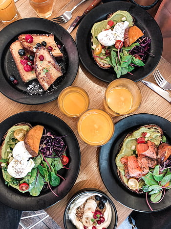 Top-down view of a vibrant brunch spread featuring avocado toast, salmon, fresh salad, and juice. HD phone wallpaper