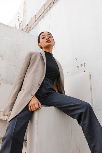 Low-angle portrait of a stylish woman in a chic outfit, exuding confidence and elegance. HD phone wallpaper