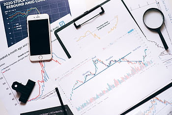 Stock market analysis setup with charts, , magnifier, and clipboards. HD wallpaper