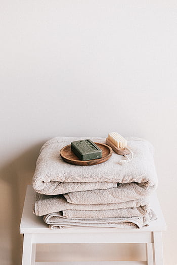 Elegant stacked towels with soap and brush create a calming bathroom vibe. HD phone wallpaper