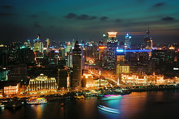 A breathtaking view of Shanghai's illuminated skyline at night over the waterfront. HD wallpaper