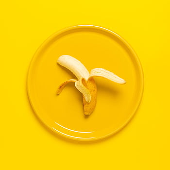 A peeled banana on a yellow plate set against a yellow background, offering vibrant color and texture contrast. HD phone wallpaper