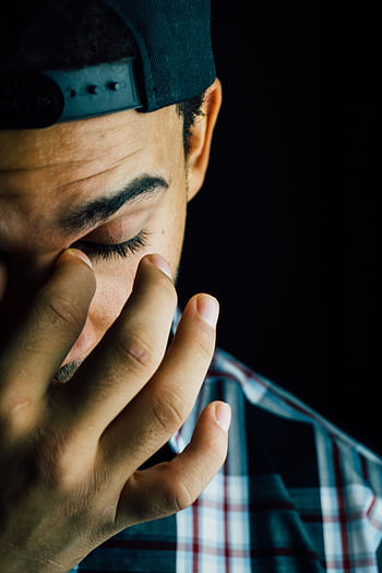 A close-up portrait capturing the emotional expression of a man in a dark studio setting. HD phone wallpaper