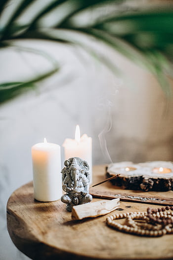 Serene still life featuring Ganesha statue, candles, and incense. HD phone wallpaper