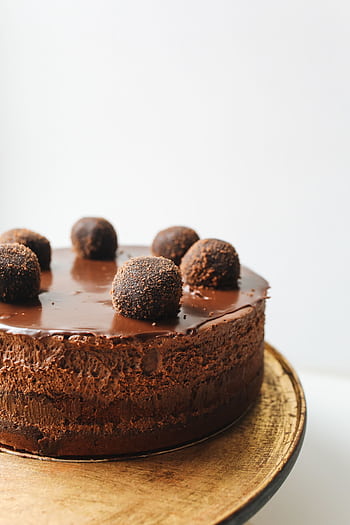 Indulge in a rich chocolate mousse cake topped with truffles, perfect for dessert lovers. HD phone wallpaper