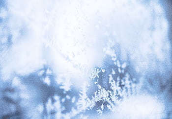 Delicate frost patterns on a window create a serene winter scene, captured in soft focus. HD wallpaper