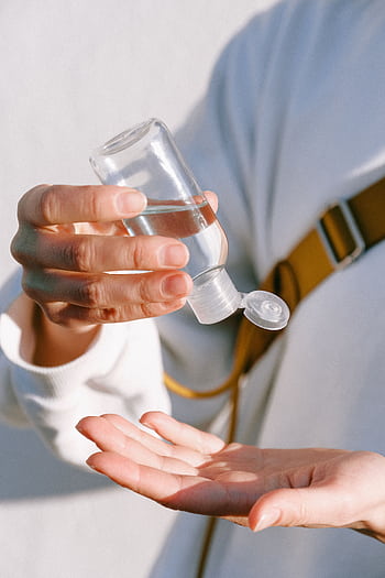 Close-up of a person applying hand sanitizer for hygiene and protection. HD phone wallpaper