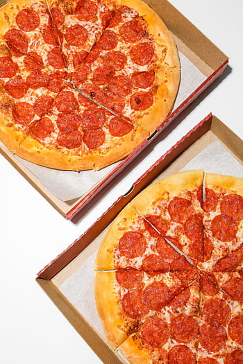 Two freshly baked pepperoni pizzas in open cardboard boxes, ready to enjoy. HD phone wallpaper