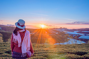 Woman standing over some mountains flanked by a village at sunrise, girl, gold, sunrise, woman, mountain, asia, sky, sun, mountains, sunset, village, horizon, morning, golden hour, snow, hat, golden, rice paddy, landscape, pink HD wallpaper