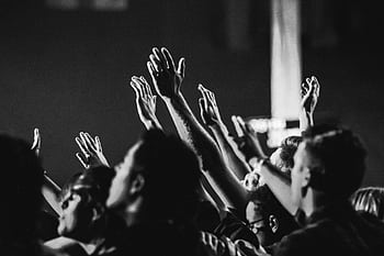Dynamic black and white of a concert audience with hands raised, capturing the energy of live music. HD wallpaper