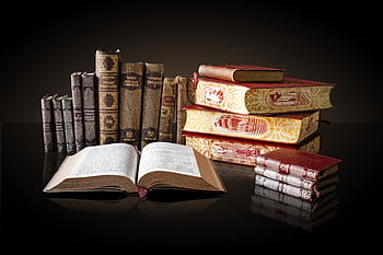 A collection of vintage books displayed elegantly on a reflective surface, ideal for education and literature themes. HD wallpaper