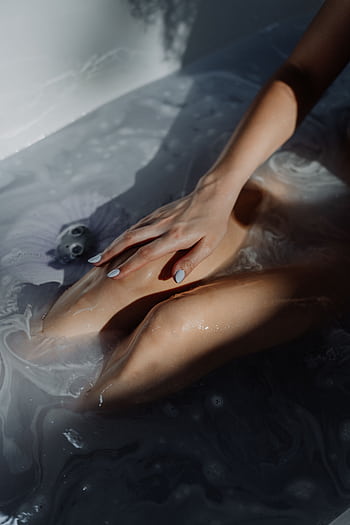 A serene and calming bath scene featuring bubbles and a gentle hand resting on a submerged body in warm water. HD phone wallpaper