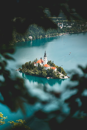 A breathtaking view of the Church of the Assumption on Lake Bled, Slovenia, surrounded by turquoise waters. HD phone wallpaper