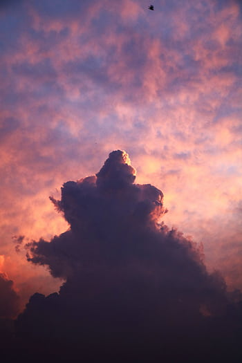 A stunning view of a dramatic cloud formation during twilight, showcasing vibrant and warm hues of a summer sky. HD phone wallpaper
