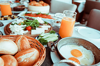 Appetizing breakfast table with orange juice, fried eggs, breads, and fresh vegetables. HD wallpaper
