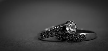 A detailed black and white close-up of elegant engagement rings with diamonds, showcasing luxury and sophistication. HD wallpaper