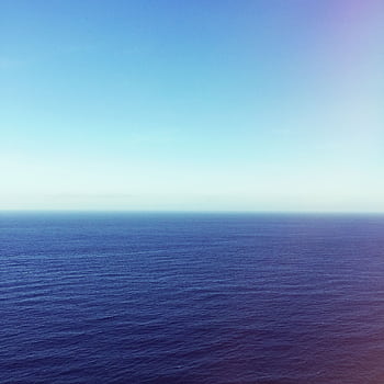 Tranquil view of a vast ocean against a clear blue sky, perfect for calm and relaxation themes. HD phone wallpaper