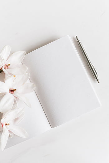Top view of a blank notebook with magnolias and a silver pen, ideal for notes or journaling. HD phone wallpaper