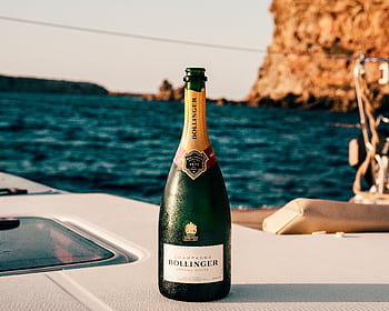 Bollinger champagne bottle on a yacht with Ibiza's ocean view, perfect for celebrations. HD wallpaper