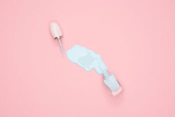 Artistic top view of blue nail polish spill on a pink background with copyspace. HD wallpaper